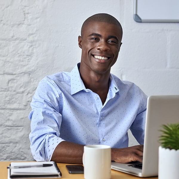 A man sitting at his desk while smiling