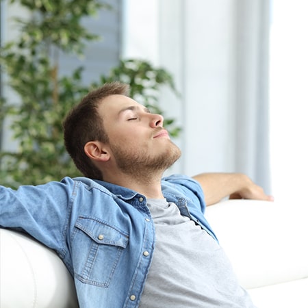 A man sitting on his sofa while relaxing
